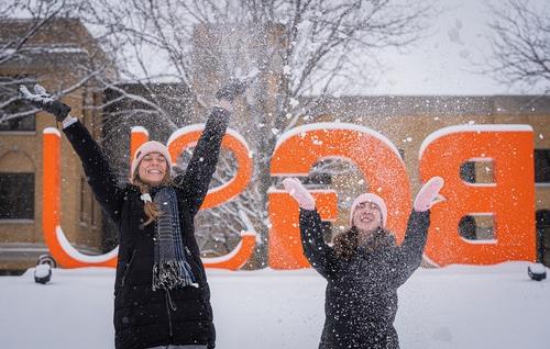 Two students throwing snow