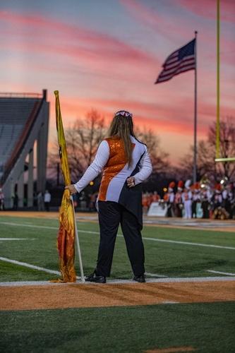 A student holding flag during sunset